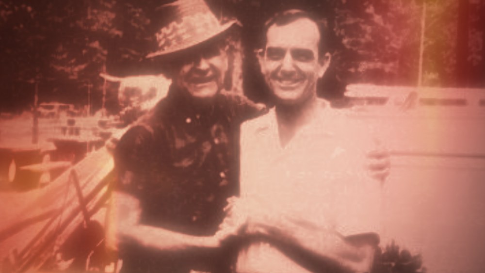 William Branham (right) holding hands with Pastor Willard Collins (left) in an outdoor setting