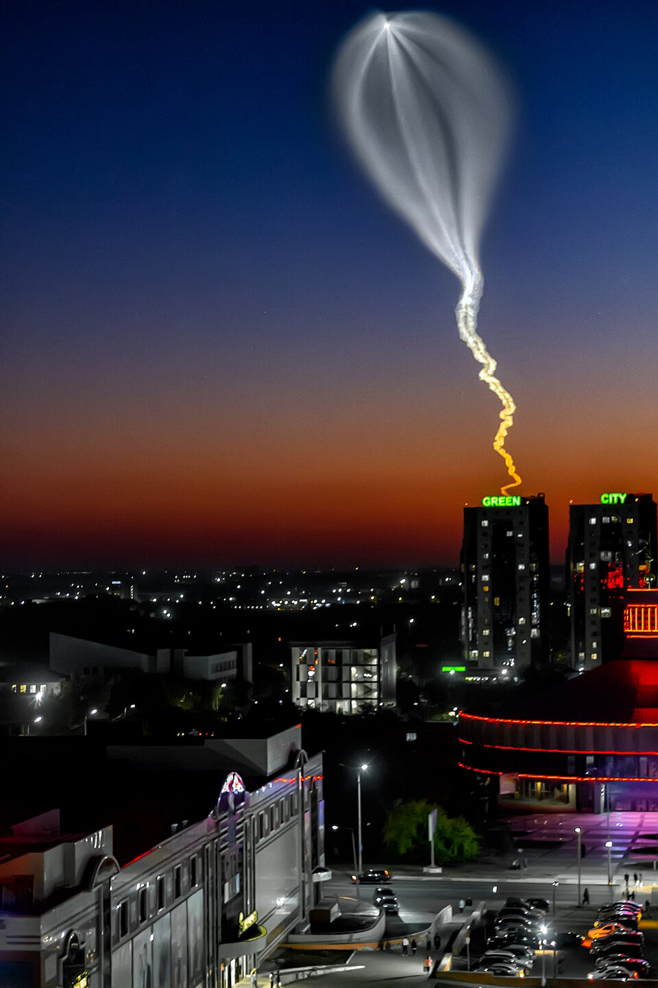 A Soyuz rocket launch forming a glowing jellyfish-shaped cloud at twilight over Baikonur